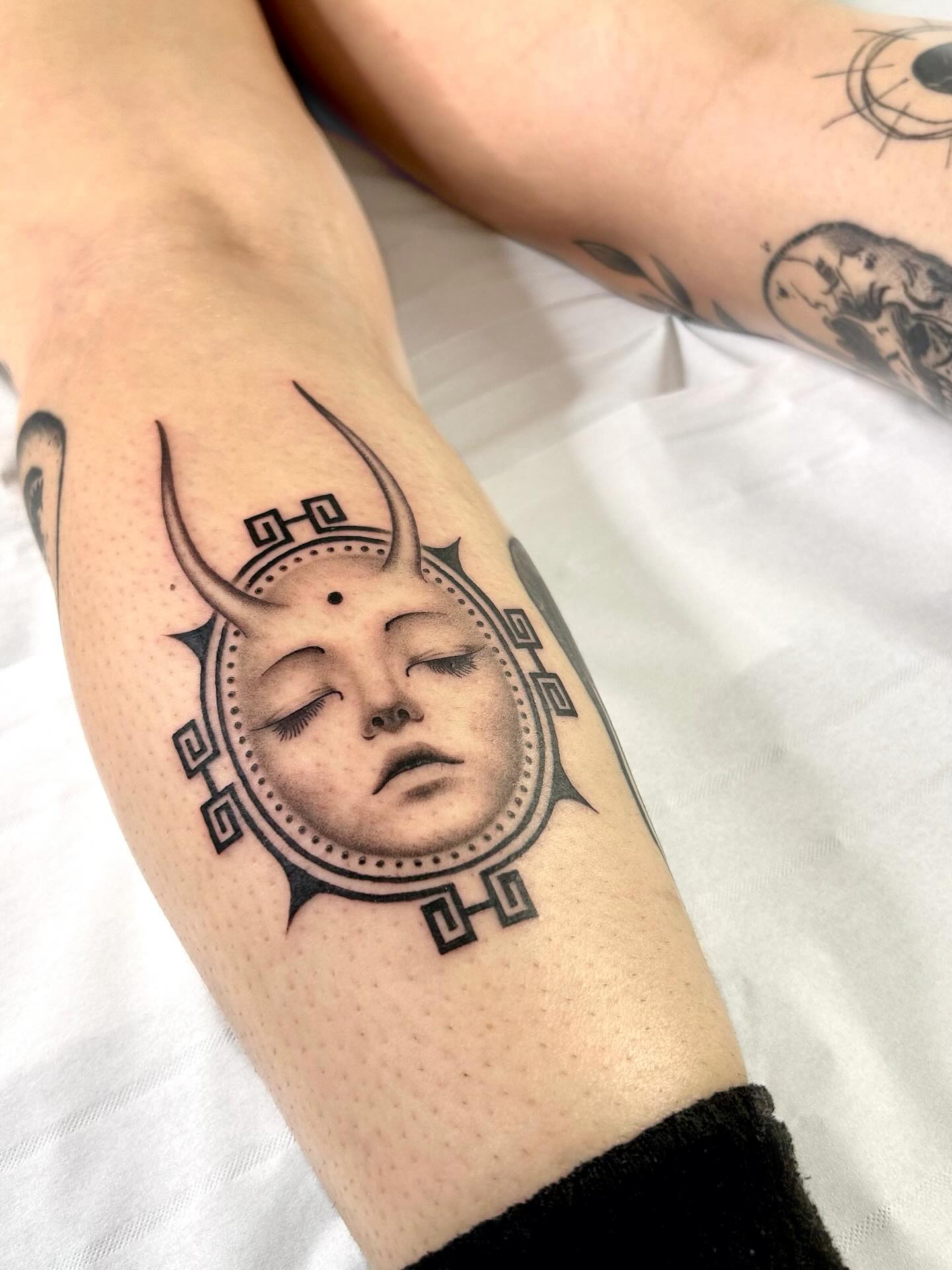 Tatouage masque solaire ornemental sur l'avant-bras